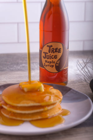 Tree Juice Maple Syrup being poured over a stack of pancakes