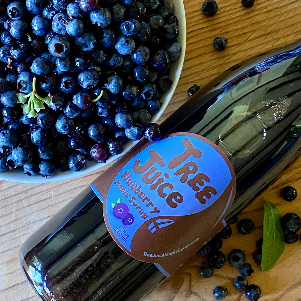 Bowl of fresh blueberries with 12oz bottle of blueberry maple syrup